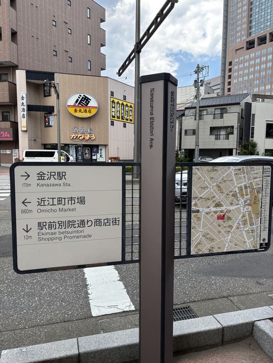 金沢駅通りに立つ案内標識。「金沢駅 170m」「近江町市場 660m」「駅前別院通り商店街 10m」と周辺地図が示されている