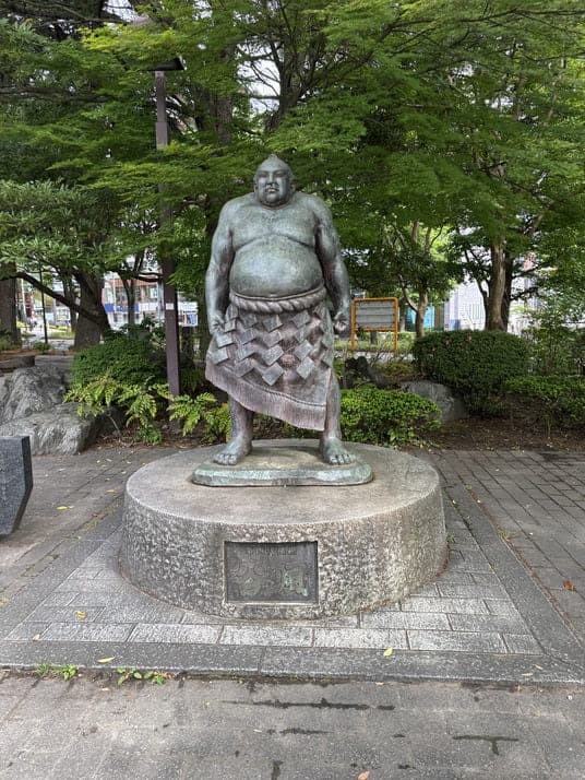 化粧まわしを着けた力士の銅像
