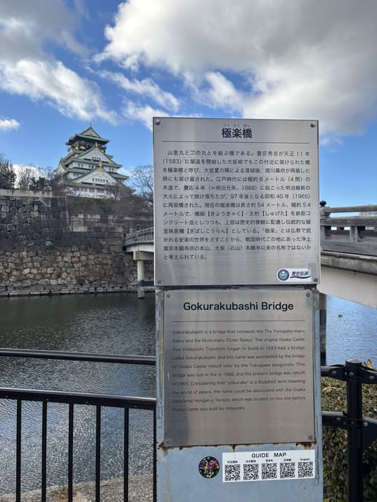 「極楽橋」の案内板。奥に大阪城の天守がそびえる